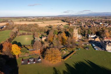 Aerial photo of the beautiful town of Bedale which is a market town in the Hambleton former district of North Yorkshire showing the beautiful town, church and motorway in the autumn time clipart