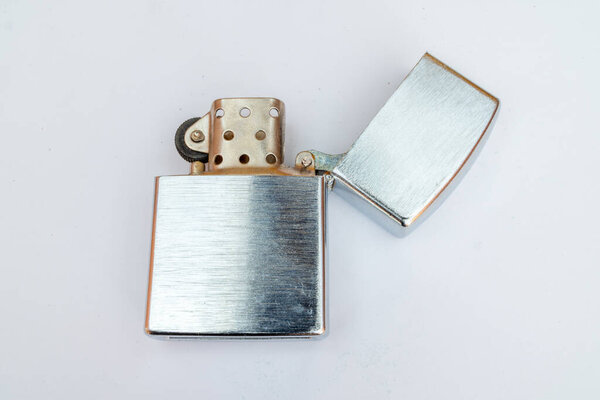 Старая зажигалка в стиле сивера 1980-х годов, заполненная маслом, показывает открытую крышку хронической зажигалки, используемой для зажигания сигар и сигарет