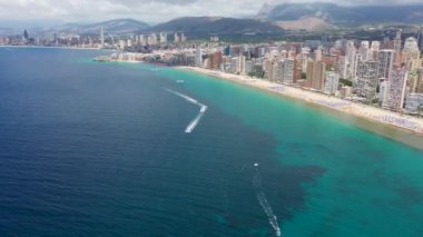 Yazın İspanya 'nın Benidorm şehrinin hava aracı görüntüleri Playa de Levante plajını, plaj şemsiyelerini ve güneşlenen insanları gösteriyor.