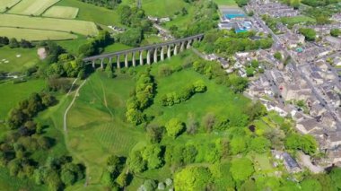 İngiltere 'nin batı Yorkshire kentindeki Bradford şehrinin metropoliten ilçesi içinde yaz mevsiminde köy ve viyadüklerin görüldüğü Thornton kasabasının insansız hava aracı görüntüleri..