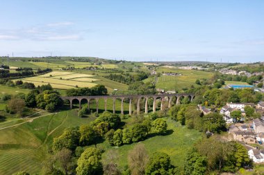 Aerial drone photo of the town of Thornton which is a village within the metropolitan borough City of Bradford in West Yorkshire, England showing the village and famous viaduct in the summer time. clipart