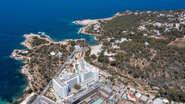 İbiza Balearic Adaları 'ndaki Sant Antoni de Portmany kasabasındaki bir kumsalın insansız hava aracı fotoğrafı İspanya' nın okyanus cephesini ve Cala Alto de Porta plajını gösteriyor..