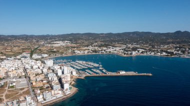 Aerial drone photo of a beach in the town of Sant Antoni de Portmany on the island of Ibiza in the Balearic Islands Spain showing the boating harbour and the beach known as Playa de San Antonio clipart