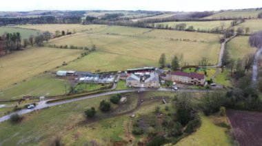 Kışın soğuk bir günde İngiltere 'nin Kuzey Yorkshire kentindeki büyük çiftçi tarlalarının ve kırsal evlerin insansız hava aracı görüntüleri yukarıdan tarlalarla çevrili bir İngiliz çiftlik evini gösteriyor..