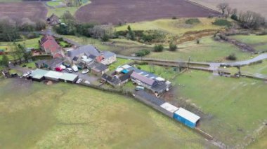 Kışın soğuk bir günde İngiltere 'nin Kuzey Yorkshire kentindeki büyük çiftçi tarlalarının ve kırsal evlerin insansız hava aracı görüntüleri yukarıdan tarlalarla çevrili bir İngiliz çiftlik evini gösteriyor..