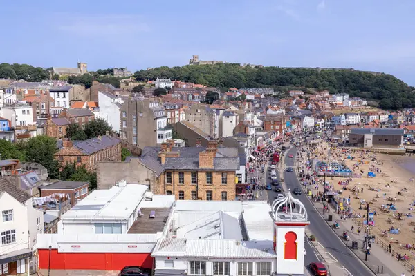 Kuzey Yorkshire, İngiltere 'de Scarborough kasabasındaki sahil cephesinin insansız hava aracı fotoğrafı sahilde ve sahilde iş yapan insanları gösteriyor.