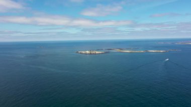 Inner Farne 'ın güney ucunda bir deniz feneri olan The Farne Lighthouse' ı gösteren İngiltere 'deki Deniz Evleri köyünün sahil kasabasının hava görüntüleri. 19. yüzyılın başlarında inşa edilmiş..
