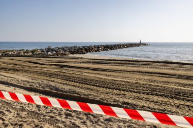 Mijas İspanya 'nın Sitio de Calahonda kasabasındaki kapalı bir plajda, kış aylarında halk plajında yapılan çalışmalar nedeniyle sahile giremeyeceğinizi gösteren bir kaset görülüyor.