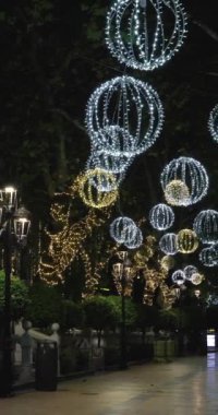 Malaga İspanya 'nın Marbella kasabasında çekilen portre görüntüleri ana yolun üzerindeki Noel ışıklarını ve Aralık ayının akşamında yollarda trafiği gösteriyor.