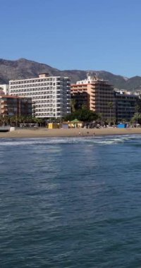 İspanya, Fuengirola kasabasındaki güzel plajın portre görüntüleri Playa de los Boliches olarak bilinen sahildeki okyanus ve sahil otellerini gösteriyor.
