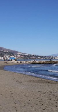 Fuengirola İspanya, 23 Aralık 2024: İspanya 'nın Fuengirola kentindeki güzel plajın portre görüntüleri okyanus önünü ve Playa de los Boliches olarak bilinen sahildeki dalgaları gösteriyor