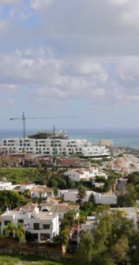 İspanya 'nın Benalmadena kenti yakınlarındaki Torremuelle kasabasının portre görüntüleri güneşli bir günde arka planda okyanus cephesiyle tepeden aşağıya bakan bir manzarayı gösteriyor.