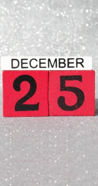 25 Aralık tarihli kırmızı blokların portre görüntüleri. Gümüş renkli arka planda Noel günü. Blokların indirilip tekrar kaldırıldığını gösteriyor.