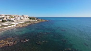 Spains Costa Del Sol 'daki Mijas kasabasında güneşli bir günde Playa del Chaparral olarak bilinen kayalık plaj cephesini gösteren hava aracı görüntüleri.