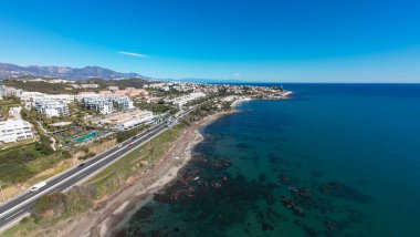 Spains Costa Del Sol 'daki Mijas kasabasındaki güzel sahil cephesinin hava aracı fotoğrafı güneşli bir günde Playa del Chaparral olarak bilinen kayalık plaj cephesini gösteriyor.