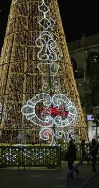Torremolinos, Malaga İspanya, 30 Aralık 2024: İspanya 'nın Torremolinos kentindeki sokakların portre görüntüleri Noel ışıkları ve büyük bir Noel ağacı gösteriyor