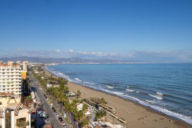 İspanya 'nın Torremolinos kentindeki sahil cephesinin havadan çekilmiş fotoğrafı güneşli bir günde okyanus sahilinin önünü, otelleri ve apartmanları gösteriyor.