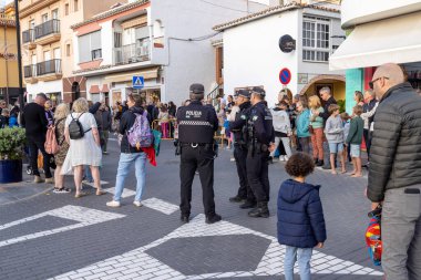 La Cala de Mijas, Malaga, İspanya 4 Ocak 2024: İspanya 'da La Cala kasabasının caddesinde sokaktaki polis memurları kalabalıkları ve yoldaki memurları gösteriyor