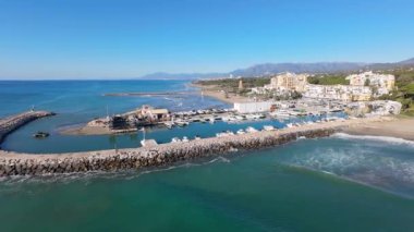 İspanya 'nın Calahonda kasabasındaki güzel sahil cephesinin hava aracı görüntüleri Marbella İspanya' daki Cabopino limanını ve parlak güneşli bir günde etrafındaki kumlu plajları gösteriyor.