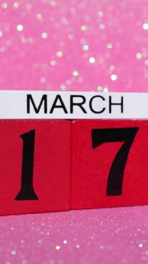 Kırmızı bir takvim bloğunun, 17 Mart 'ta, yani İrlanda St Patricks' in pembe bir arka planda kutlama günü olan tarihi gösterilirken tekrar çekilen portre görüntüleri.