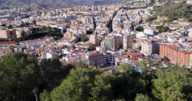 İspanya 'nın Malaga şehrinin caddelerinin görüntülerini tarıyorum. Güneşli bir günde şehrin arka planında yüksek katlı daireler ve dağlar olan şehir merkezinin hava manzarasını gösteriyorum.