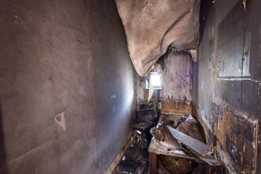 Son derece yıkık dökük bir mülkün fotoğrafı büyük bir yangında yanmış duvarları, banyodaki tavanı ve yanmış evdeki yanmış banyoyu gösteriyor.