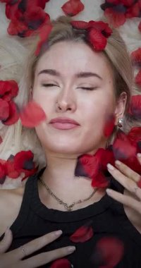Çekici bir sarışının portre görüntüleri, gül yapraklarıyla uzanmış romantik kadın sevgililer günü aşkının baştan çıkarma konseptine fırlatılıyor.