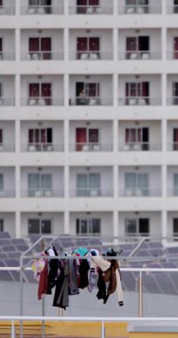 Temiz kıyafetlerin kuruduğu ve bir İspanyol apartman bloğunun tepesindeki çamaşır ipinin üzerine monte edildiği bir portre. Çamaşırların yüksek binanın tepesinde kuruyup rüzgarın çamaşırları yıkadığı görülüyor.