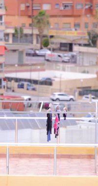 Temiz kıyafetlerin kuruduğu ve bir İspanyol apartman bloğunun tepesindeki çamaşır ipinin üzerine monte edildiği bir portre. Çamaşırların yüksek binanın tepesinde kuruyup rüzgarın çamaşırları yıkadığı görülüyor.