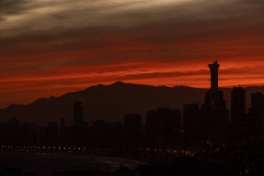 İspanya 'nın eski Benidorm kasabasında akşam vakti güneşin batışının fotoğrafı. Yazın gökyüzünde bulutların yükseldiği güzel kırmızı güneşi gösteriyor.