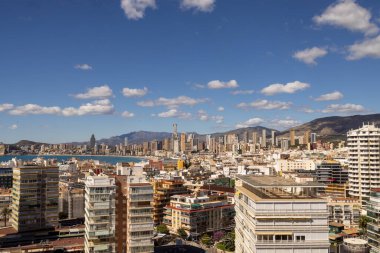 Benidorm İspanya, 20 Mart 2025: İspanya 'nın eski Benidorm kasabasına bakan fotoğraf, yüksek binalar ve yüksek binalarla çevrili Batı Sahili Gezinti Alanı' nı gösteriyor.