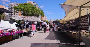 Finestrat, Alicante, İspanya 16 Mart 2025: İspanya 'nın ünlü pazar kasabası Finestrat' ta, güneşli bir günde insanların alışveriş yaptığı tezgahları gösteren görüntüler