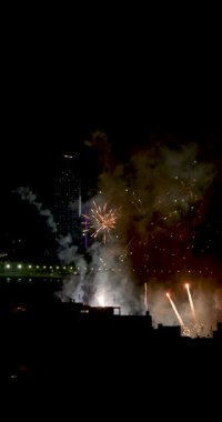 İspanya 'nın eski Benidorm kasabasına bakan dikey bir portre. Gece sahilde havai fişekler gösteriliyor. Arka planda bir İspanyol festivalini kutlayan West Beach gezinti güvertesi var.