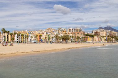 Villajoyosa İspanya, 15 Mart 2025: İspanya 'nın güzel bir kasabası olan Villajoyosa' nın fotoğrafı İspanyol köyünde yazın her iki tarafında renkli evler olan küçük bir caddeyi gösteriyor