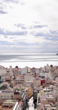 İspanya 'nın Benidorm kentinde çekilen dikey görüntü, arka planda Platja de Ponent veya West Beach gezinti güvertesi olarak bilinen eski kenti gösteriyor.