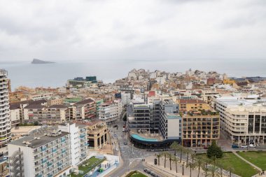 Benidorm İspanya, 10 Mart 2025: İspanya 'nın eski Benidorm kasabasına bakan fotoğraf, güneşli bir günde yüksek katlı apartmanlar, Poniente Sahili ve arka planda dağları gösteriyor