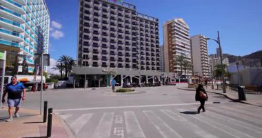 Benidorm İspanya, 27. Maç 2025: İspanya 'nın Benidorm kasabasının güneşli bir günde ünlü Flash Hotel' i ve dışarıdaki yolu gösteren yavaş çekim görüntüleri