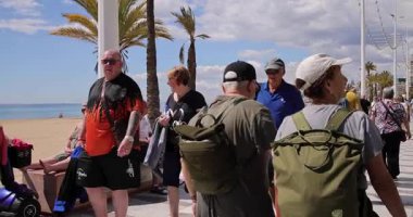 Benidorm İspanya, 27. Maç 2025: İspanya 'nın Benidorm kasabasının yavaş çekim görüntüleri güneşli bir günde Levante Sahili' nin yanında yürüyen insanları ve turistleri gösteriyor.