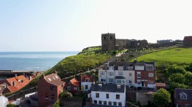 Doğu Yorkshire 'daki Whitby sahil kasabasının insansız hava aracı görüntüleri tarihi İngiliz sahil kasabasını ve tepenin üstündeki St. Mary Kilisesini gösteriyor.