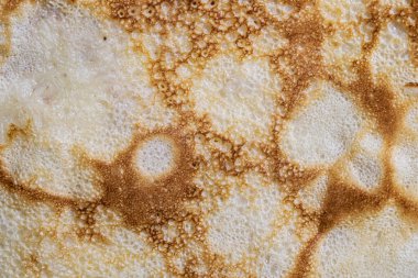 Pancake surface texture and pattern. Close-up of thin hot pancakes in a plate. Traditional rustic food. Graphic resource. Table top view.