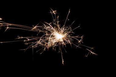 Burning sparkler isolated on black background. Fireworks theme. Light effect and texture. Christmas and new year decoration.