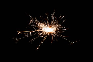 Burning sparkler isolated on black background. Fireworks theme. Light effect and texture. Christmas and new year decoration.