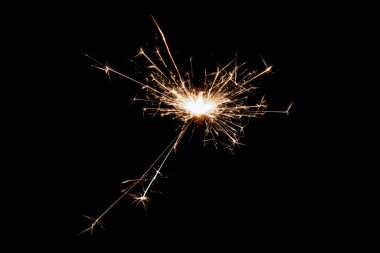 Burning sparkler isolated on black background. Fireworks theme. Light effect and texture. Christmas and new year decoration.