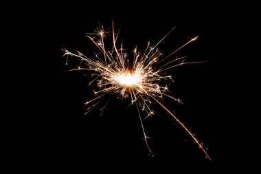 Burning sparkler isolated on black background. Fireworks theme. Light effect and texture. Christmas and new year decoration.