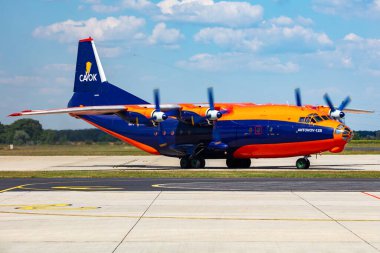 Gyor, Macaristan - 7 Temmuz 2023: Cavok Air Antonov An-12 kargo uçağı marshaller ile havaalanı apronunda. Hava nakliyesi ve nakliyesi. Havacılık ve uçak. Ulaşım endüstrisi. Küresel uluslararası ulaşım. Uç ve uç.