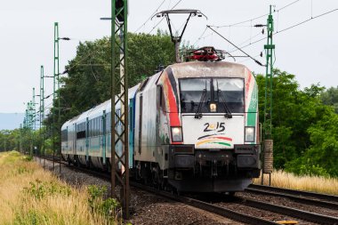 Komarom, Macaristan - 14 Haziran 2023: MAV Macar Devlet Demiryolları. Uluslararası ve bölgesel demiryolu taşımacılığı. Yolcu yük treni istasyona ayarlandı. Toplu taşıma.