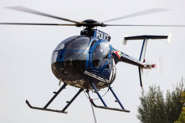 Zamardi, Hungary - September 16, 2020: Hungarian air police MD500 helicopter flying operation. SAR Search and rescue mission with rope. clipart