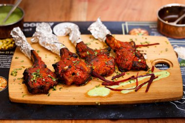 Juicy chops made of lamb lollipops. Served on a board with Green Goddess sauce