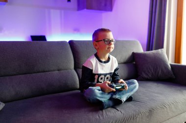 Little boy Danya plays on a game console. Emotionally reacts to victory and defeat.