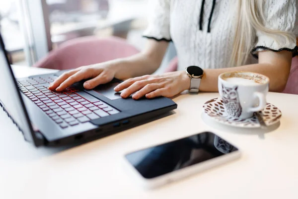 stock image A girl is learning programming over a cup of coffee in a coffee shop. Distance learning